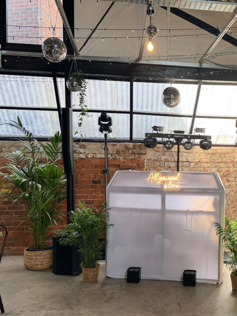 tropical plants frame a photobooth at a wedding.