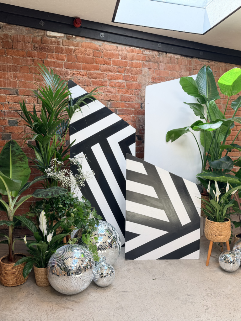Monochrome wooden ceremony with Disco balls, foliage and plants in an industrial setting