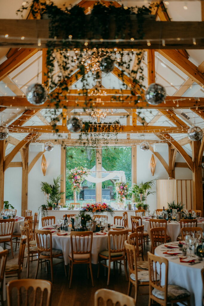 Disco ball wedding décor styled with trailing houseplants and botanical details, combining modern wedding styling with living greenery.