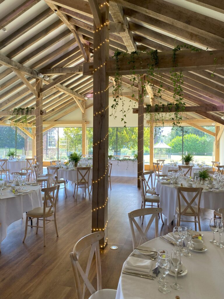Barn wedding venue styled with hanging plant chandeliers, disco balls and botanical wedding décor creating a dramatic ceiling installation.