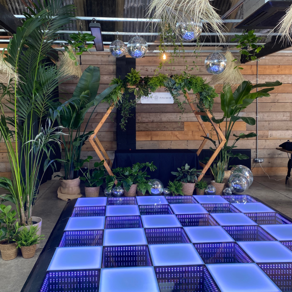 Disco balls filled with living plants hanging above a wedding dance floor creating unique botanical wedding evening décor.