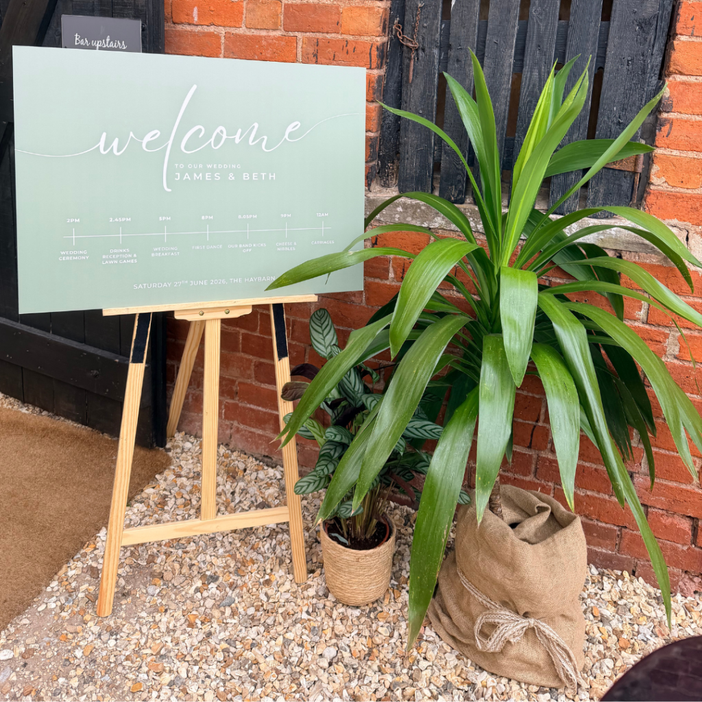 Welcome sign styled with living plants for a botanical wedding, featuring tropical plants and sustainable wedding décor to create a beautiful wedding entrance.