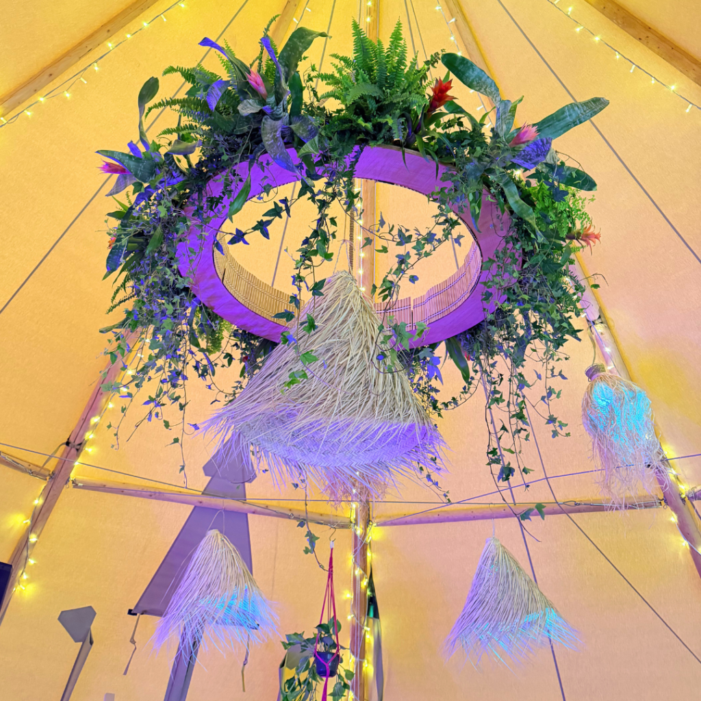 Botanical hanging wedding chandelier decorated with tropical plants and suspended floral-inspired styling above the dance floor.