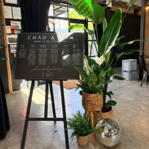 Wedding seating plan decorated with living plants, disco balls and tropical foliage creating a stunning botanical wedding display for guests to find their tables.