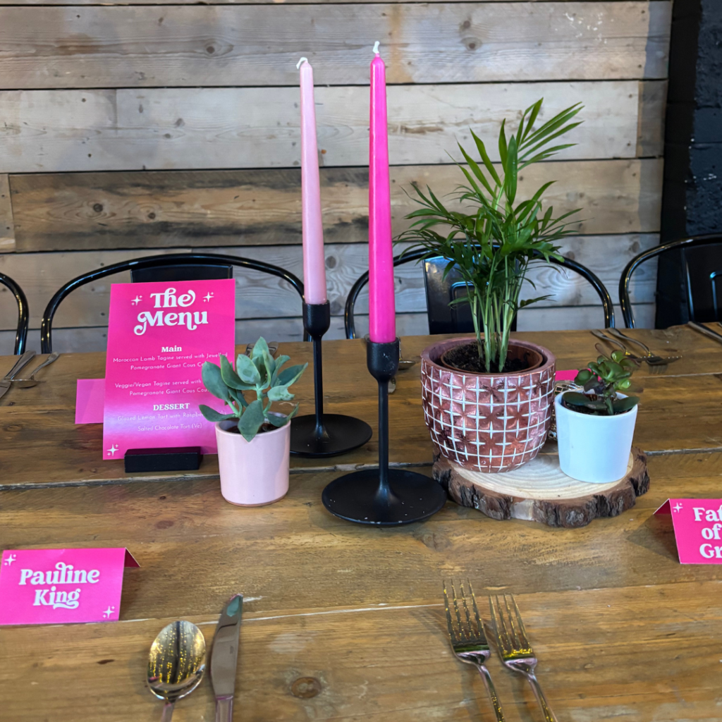 Simple doesn’t have to mean plain. A small collection of living plants paired with statement candles and colourful details creates a clean, contemporary table centrepiece with plenty of personality.